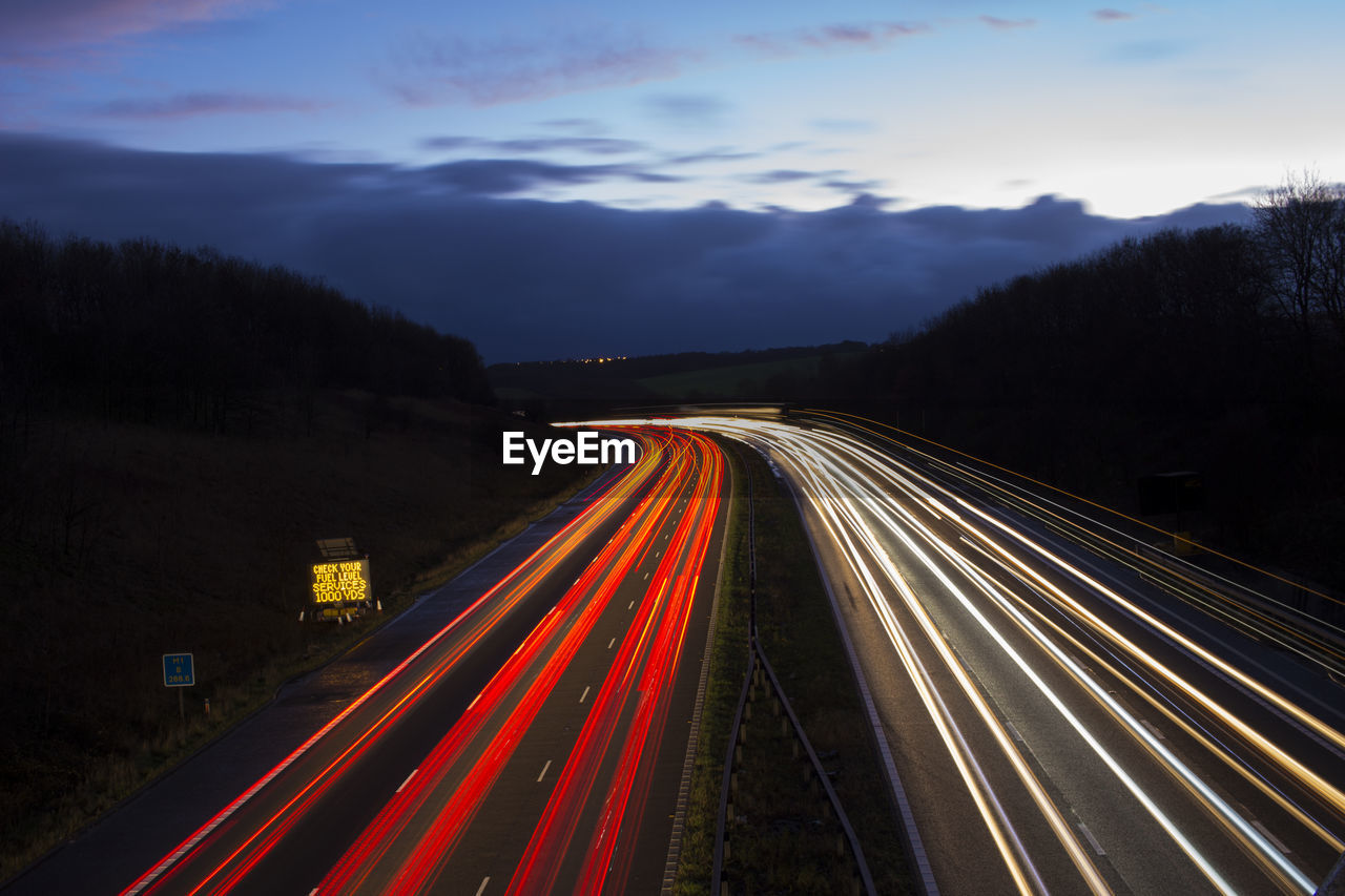 High angle view of light trails on two lane highway at dusk