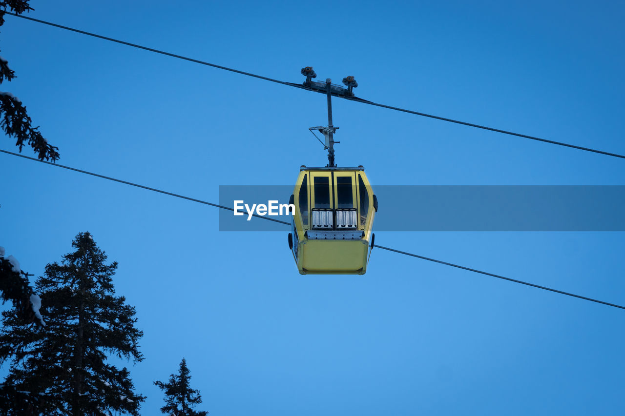 Low angle view of overhead cable car against sky