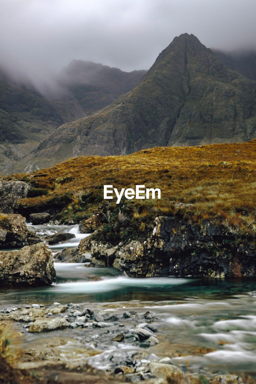 Scenic view of river and mountains against sky