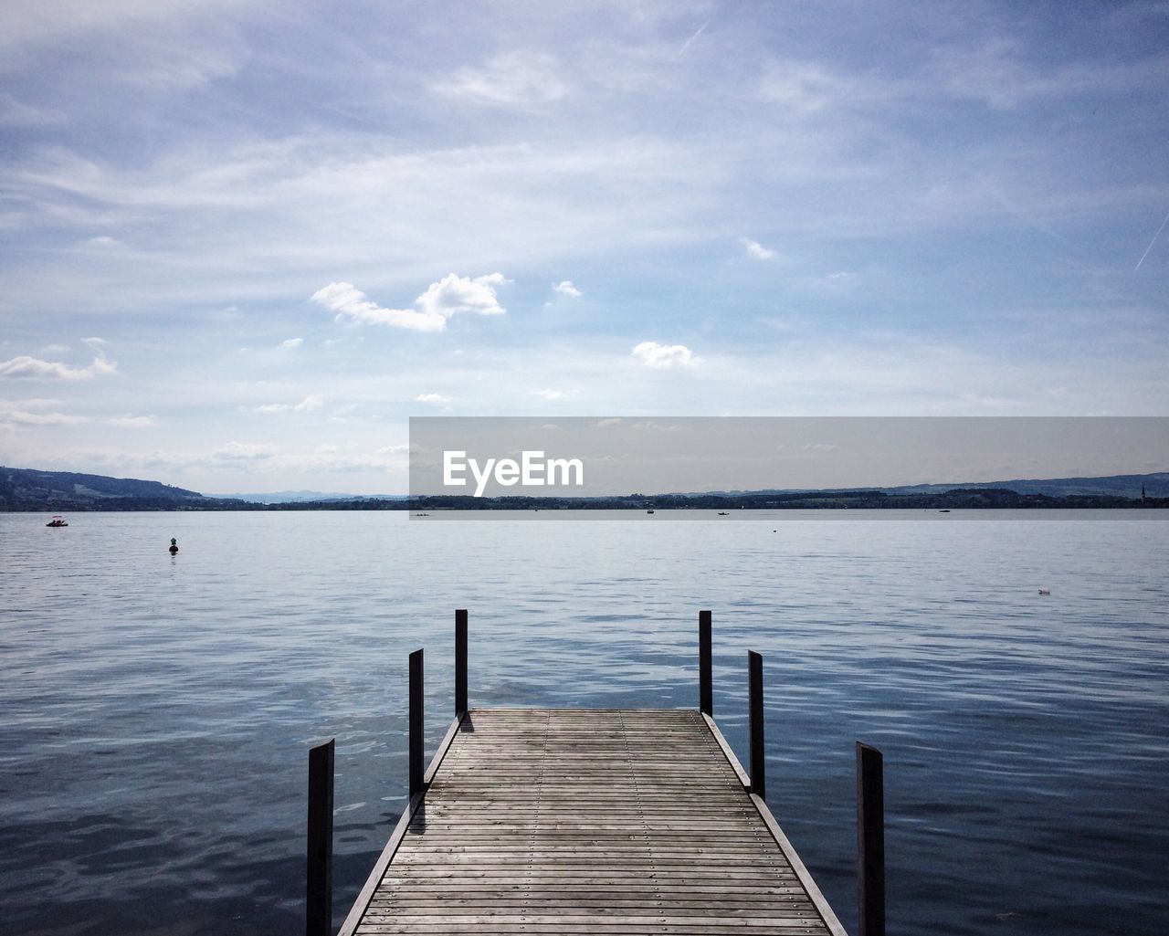 Jetty over lake against sky