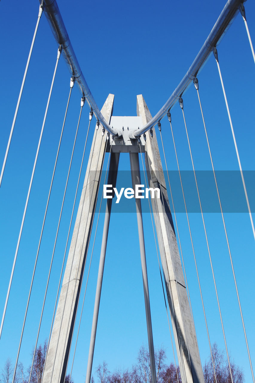 Low angle view of suspension bridge against clear blue sky