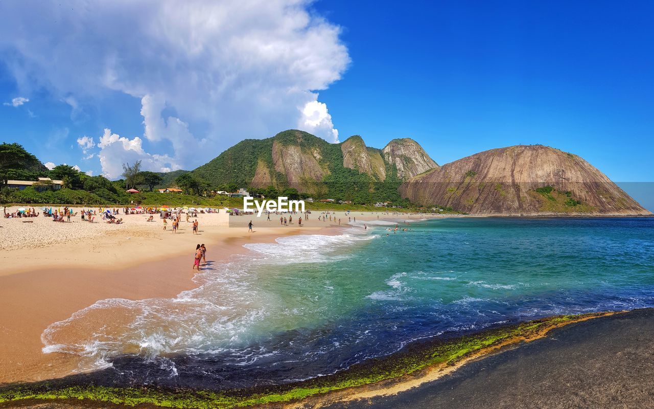 People on beach against blue sky