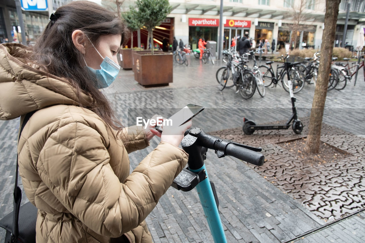 Brussels belgium - 01.31.2022 a young woman in a warm down jacket and a mask