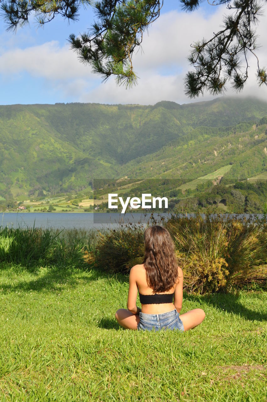 Woman sitting on grassy field