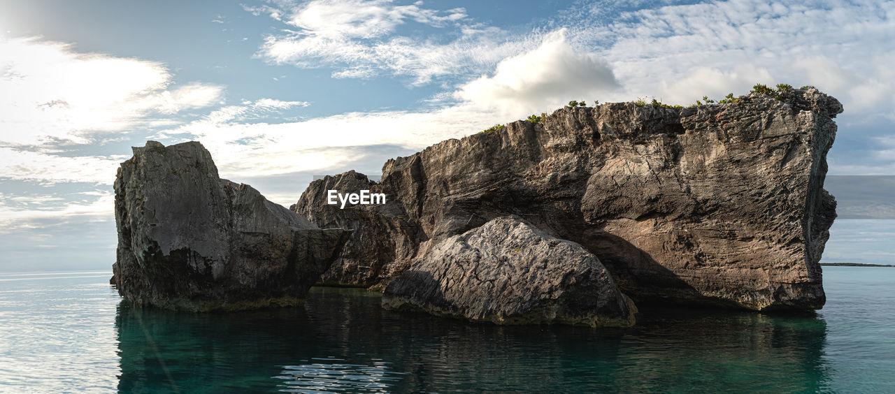 Rock formations in sea against sky