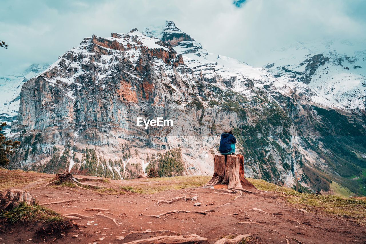 FULL LENGTH REAR VIEW OF PERSON STANDING ON ROCK