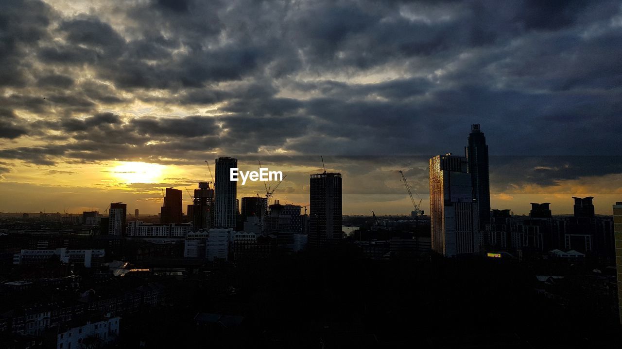 VIEW OF CITYSCAPE AGAINST CLOUDY SKY