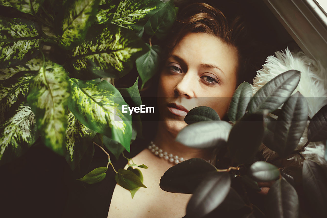 Close-up portrait of woman by plants