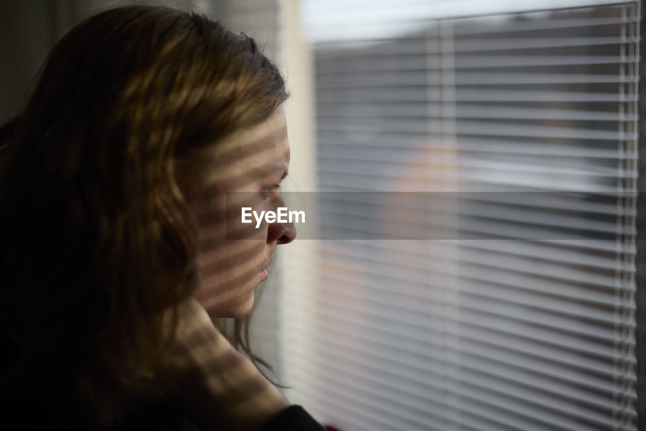 View of woman looking through window