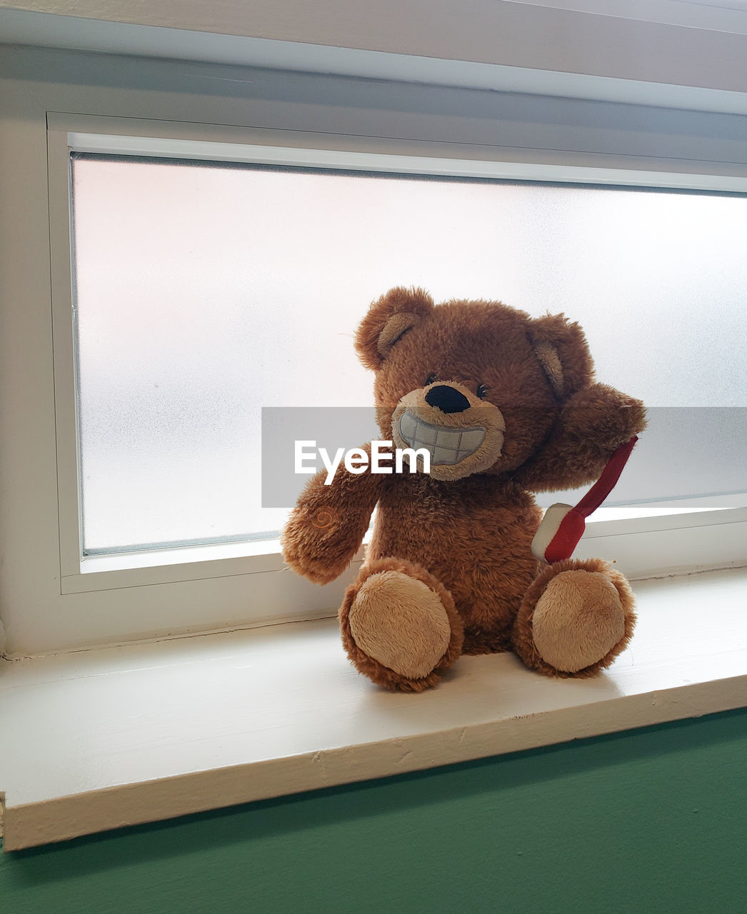 Close-up of stuffed toy on window sill at home