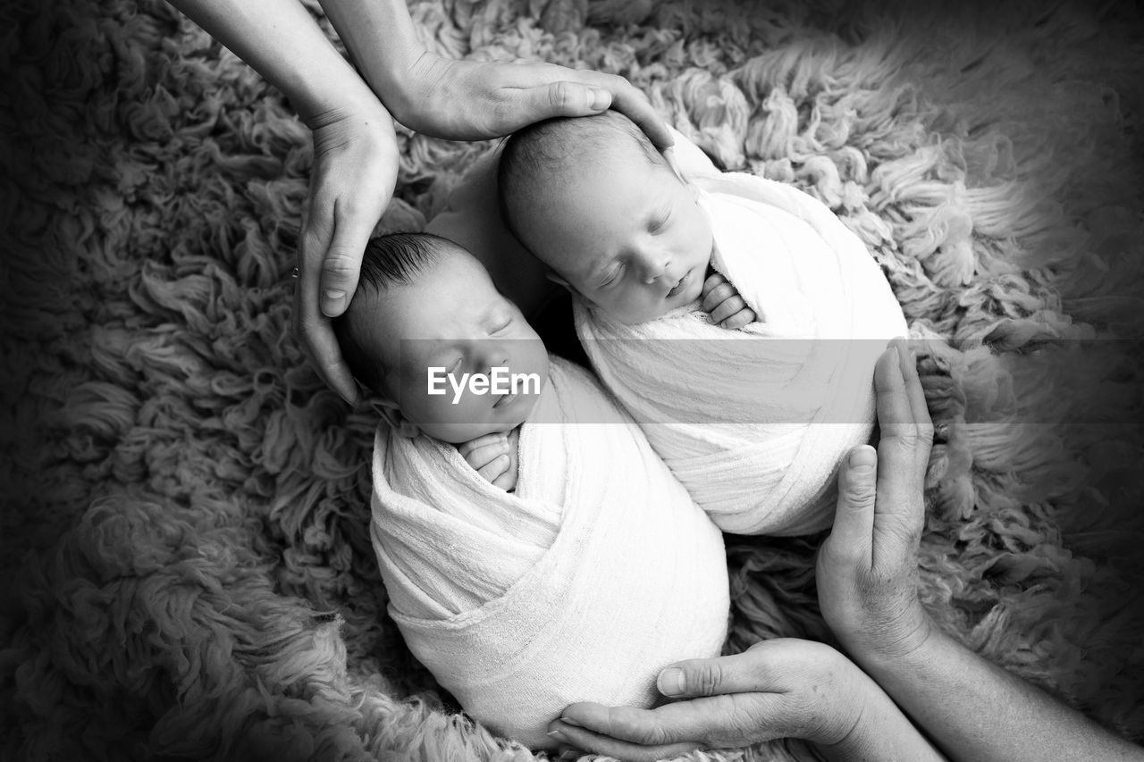 High angle view of cute babies lying on bed