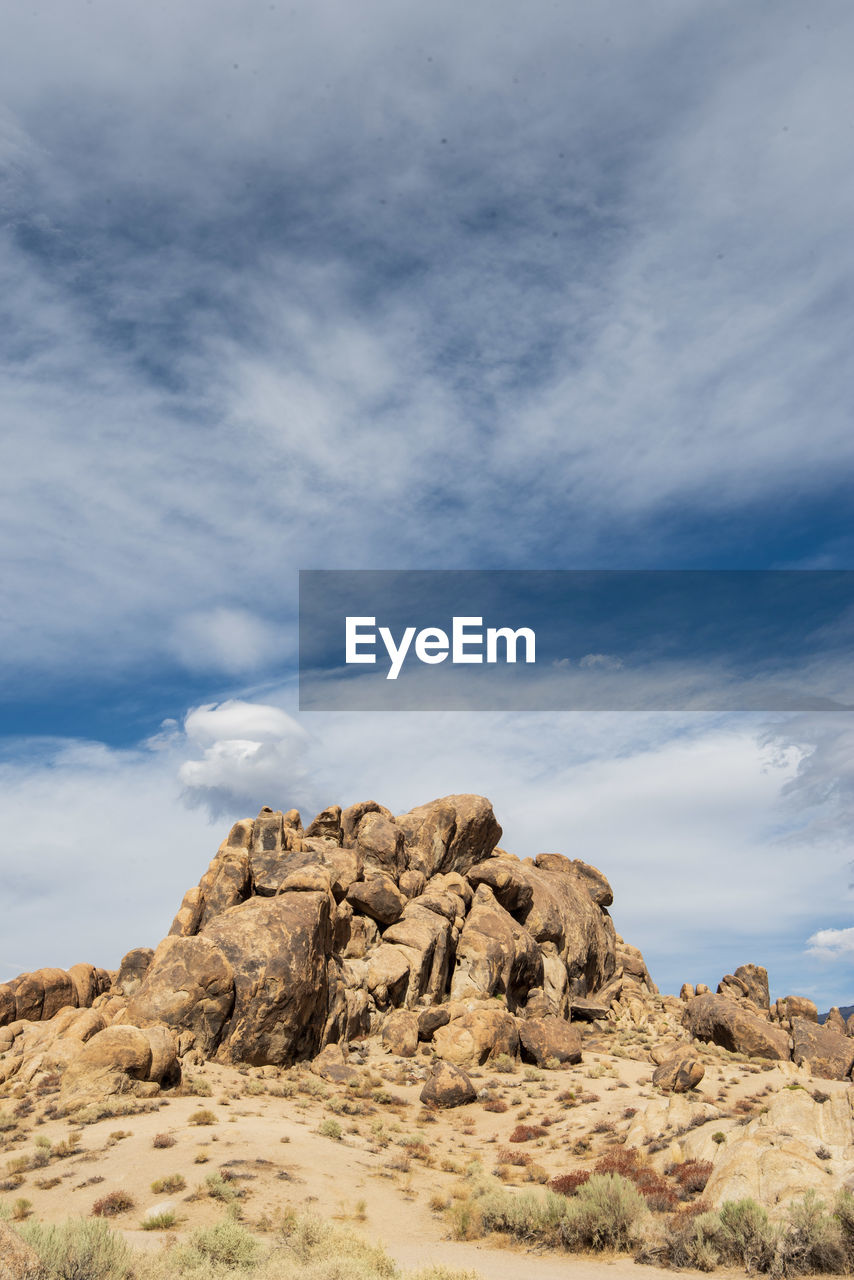 Low angle view of rock formations against sky filled with cloud layers