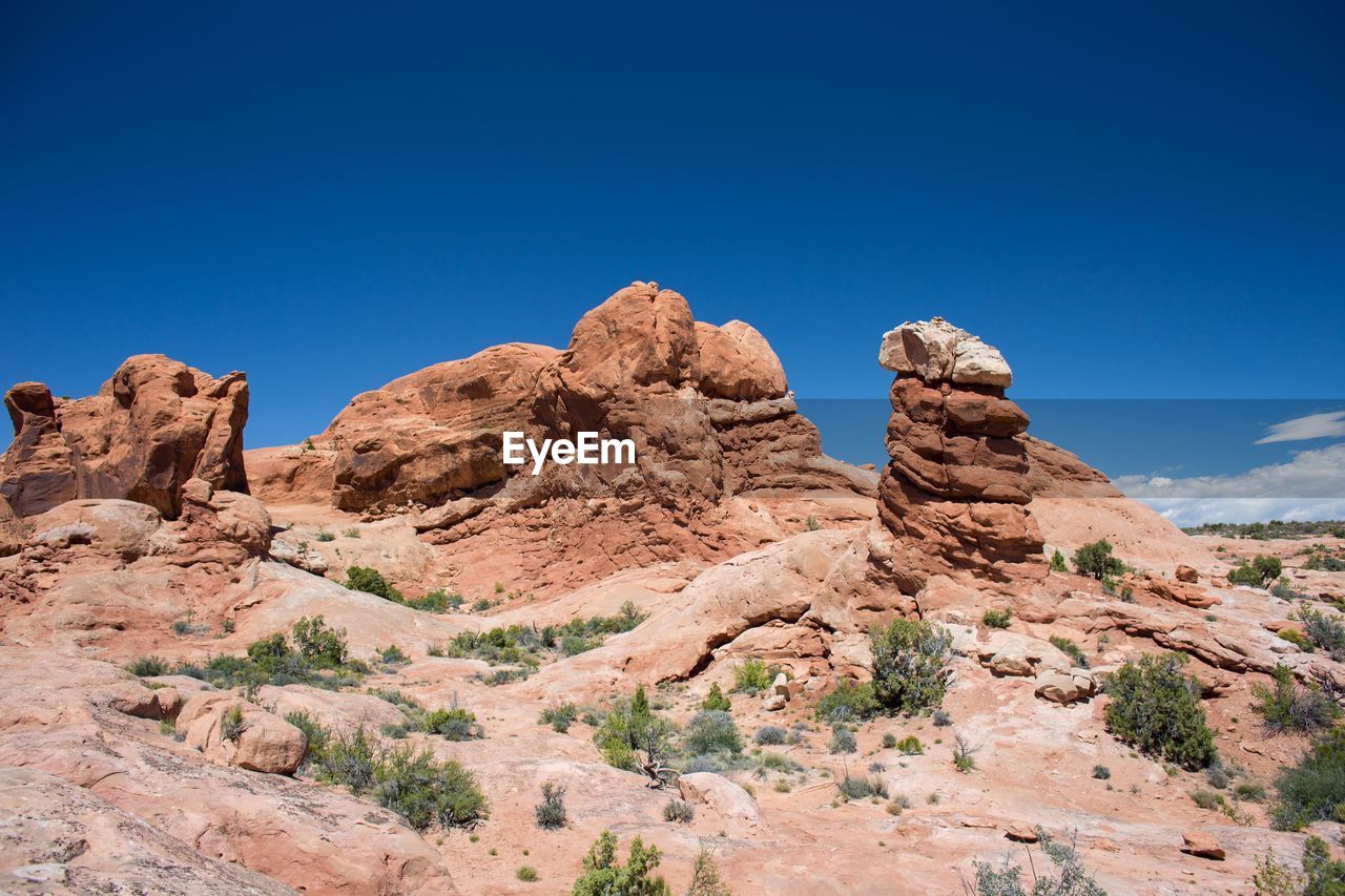 Low angle view of rock formation against blue sky at arches national park