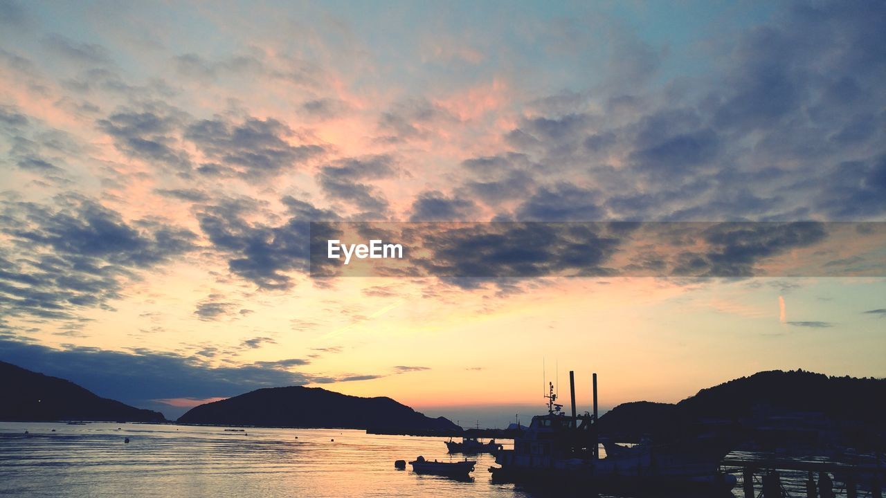 SILHOUETTE BOATS ON SEA AGAINST SKY DURING SUNSET