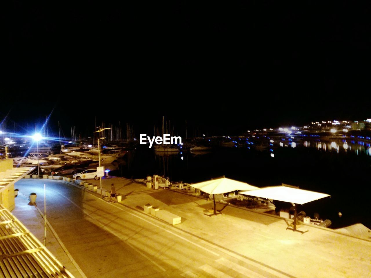 HIGH ANGLE VIEW OF ILLUMINATED STREET AGAINST SKY AT NIGHT