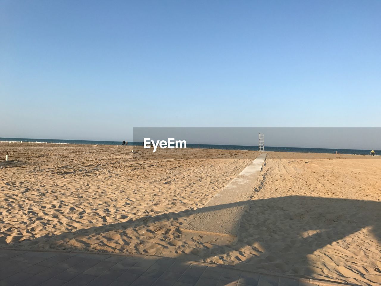 Scenic view of beach against clear blue sky