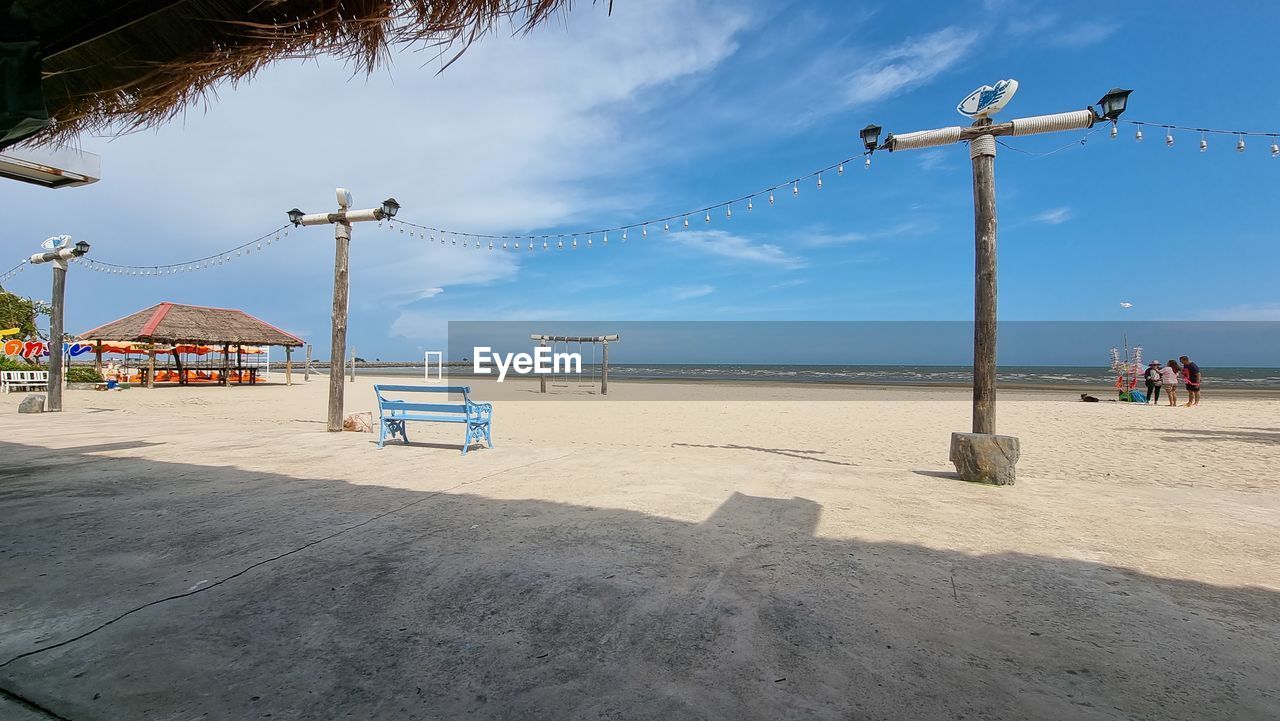 beach, sky, land, water, sea, walkway, nature, sand, coast, boardwalk, architecture, cloud, shore, vacation, body of water, travel destinations, beauty in nature, day, holiday, ocean, scenics - nature, built structure, trip, blue, tranquility, outdoors, sunlight, travel, tranquil scene, horizon, coastline, horizon over water, hut, no people, summer, tourism, transportation, sunny