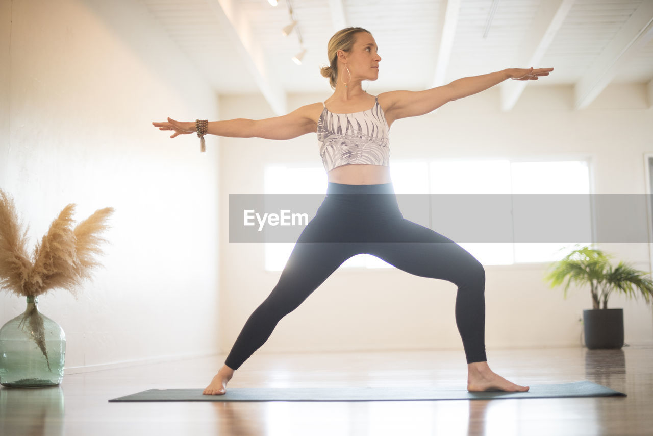 A girl practicing yoga in warrior 2 pose.