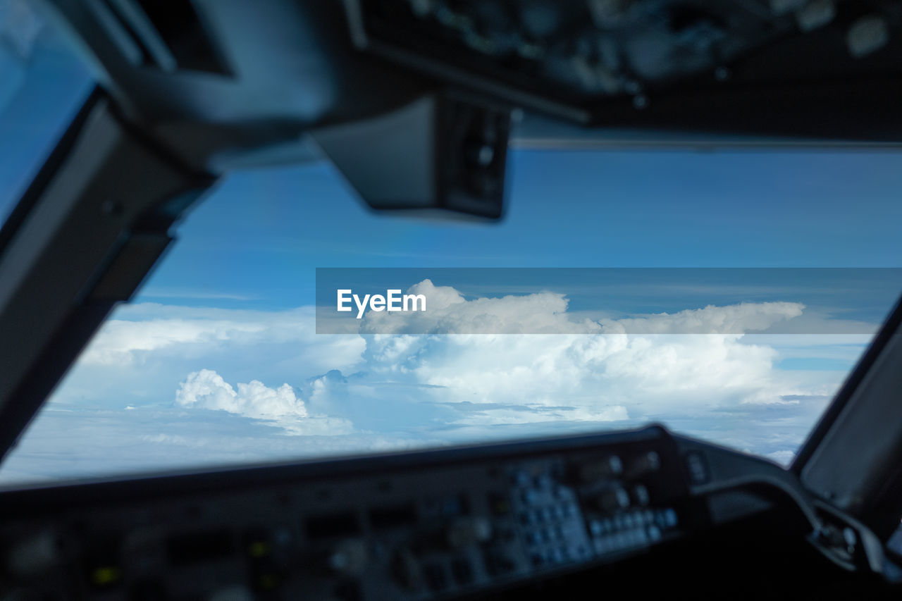 AIRPLANE WINDOW AGAINST SKY SEEN THROUGH GLASS