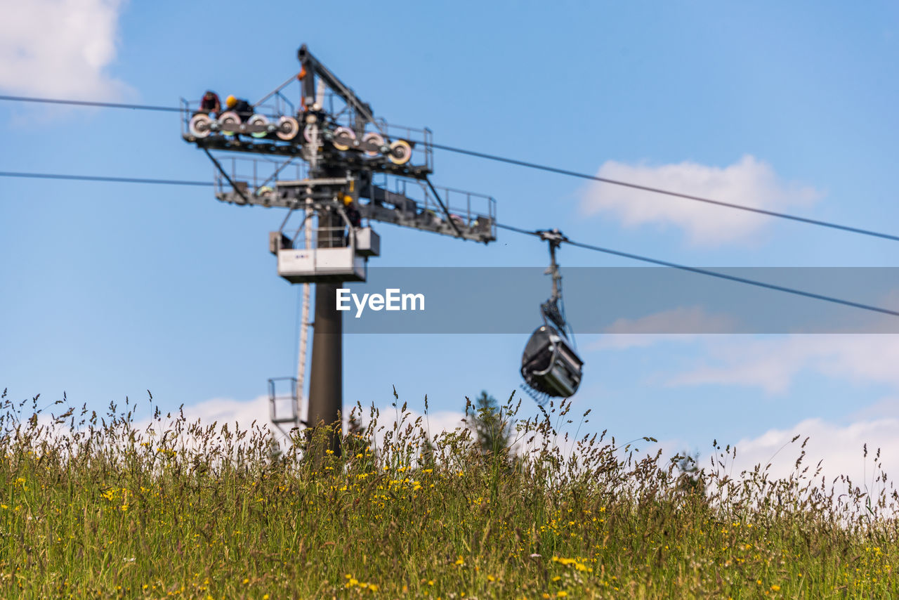 An alpine meadow and blurred technical support of the ski lift during the review and maintenance.