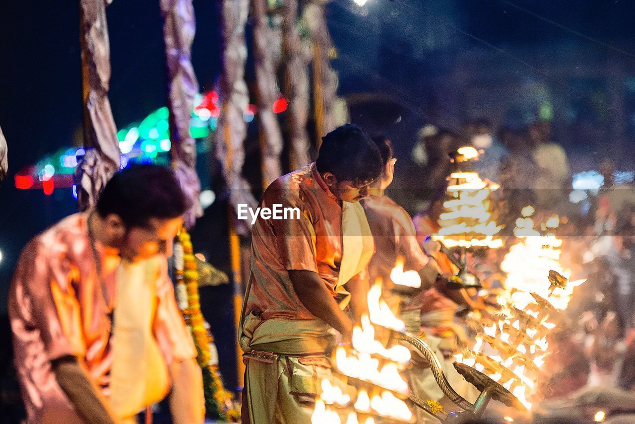People holding lit diya at temple