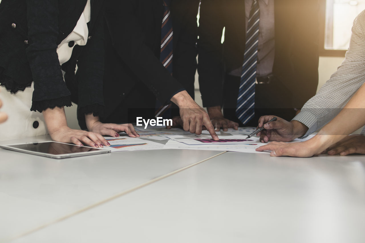 Colleagues working over graph at table in office