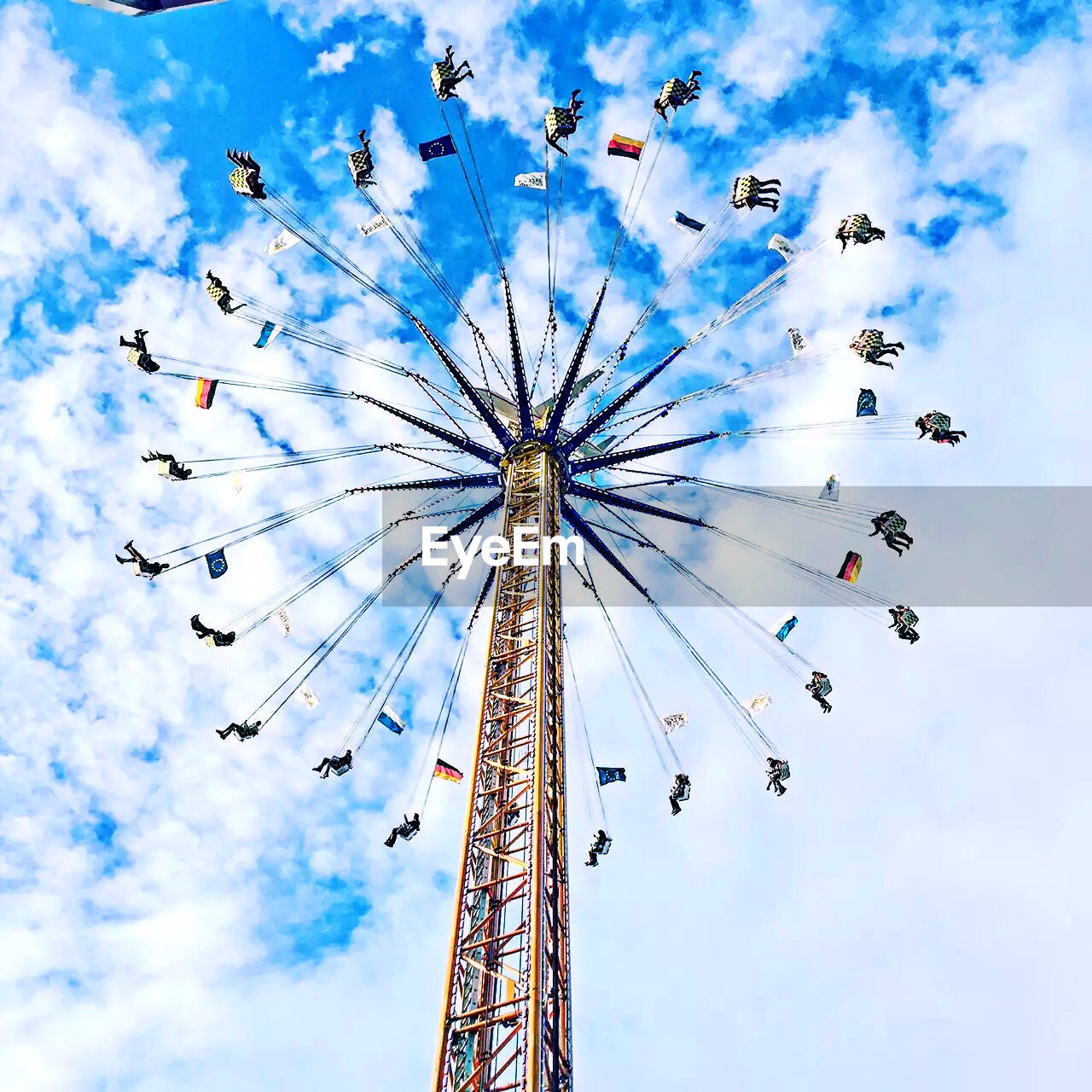 Low angle view of chain swing ride against sky