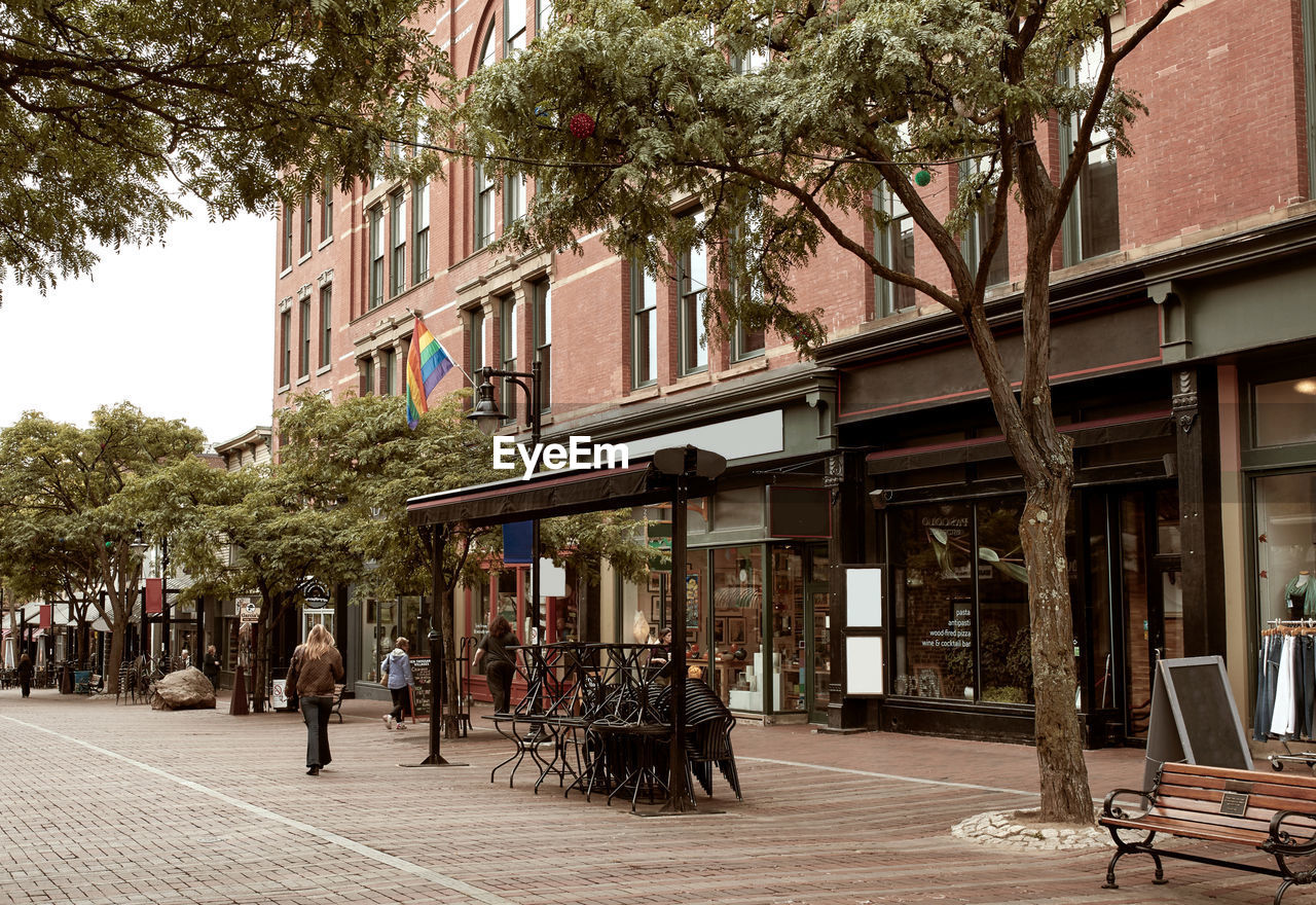 PEOPLE WALKING ON STREET AGAINST BUILDINGS