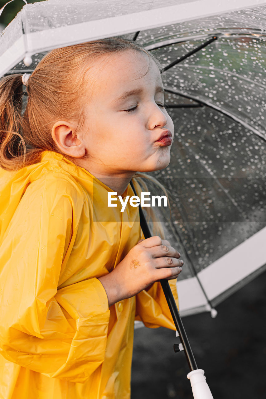Girl holding wet umbrella during rainy season