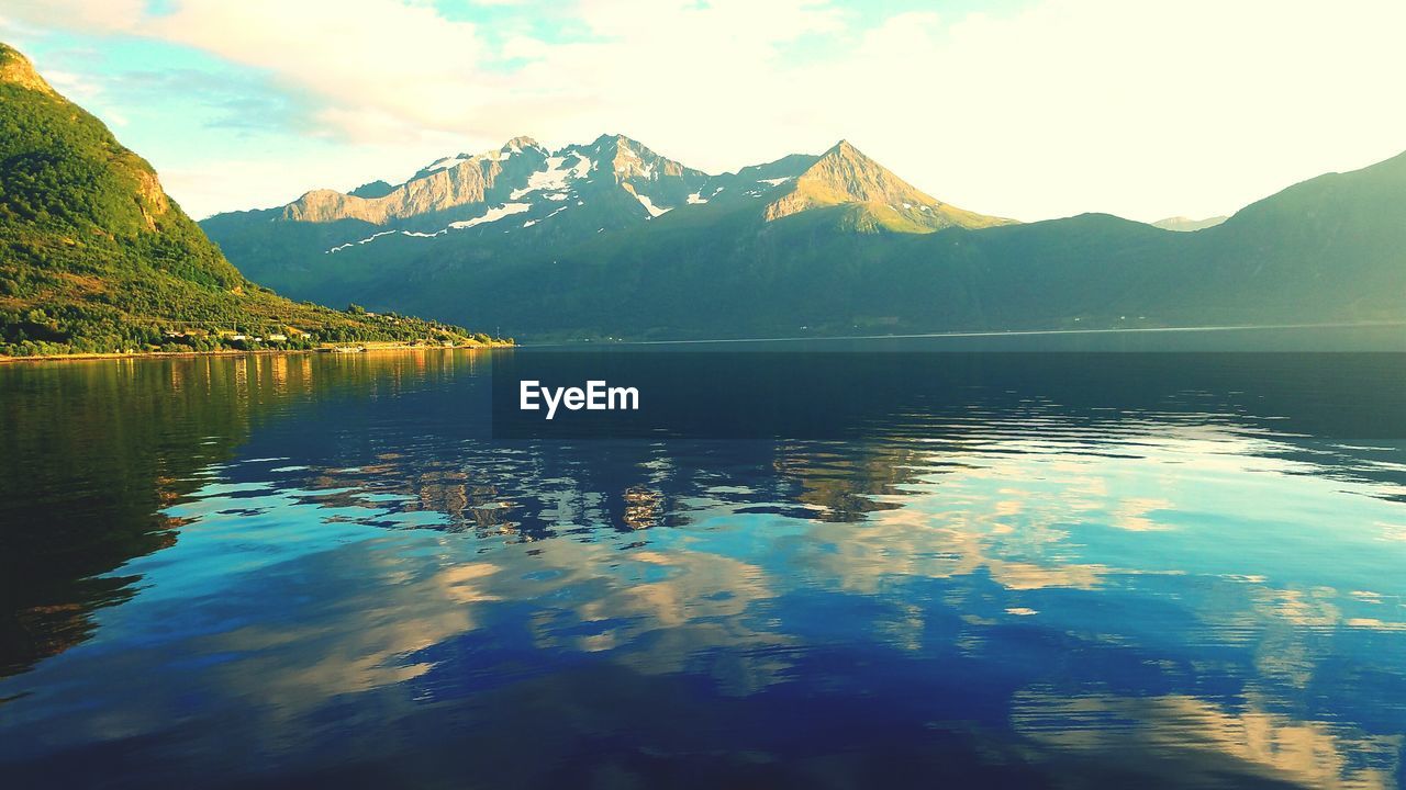 SCENIC VIEW OF LAKE BY MOUNTAIN AGAINST SKY