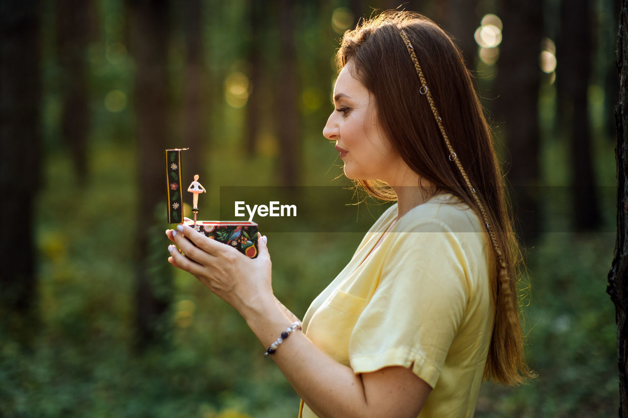 Childhood trauma in adults. outdoor portrait of woman holding a music box in her hands