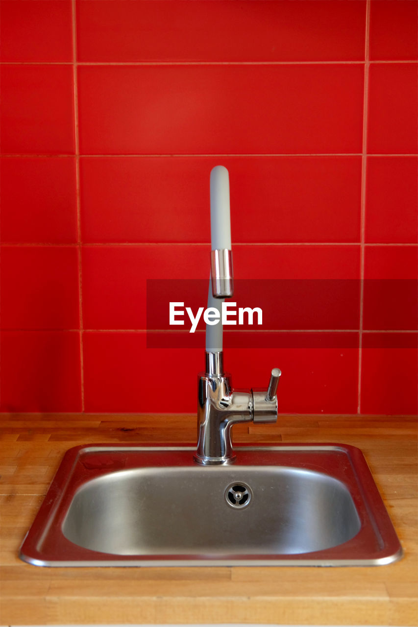home, domestic room, sink, faucet, bathroom, plumbing fixture, tap, flooring, domestic bathroom, room, hygiene, household equipment, indoors, tile, floor, bathroom sink, home interior, red, no people, cleaning, metal, domestic kitchen, domestic life, chrome, wash bowl, kitchen, nature, wall - building feature