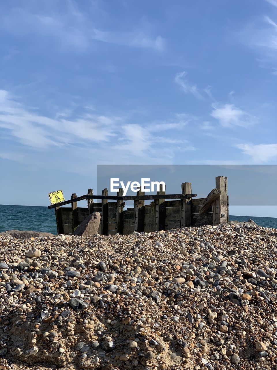 STONE WALL ON BEACH AGAINST SKY