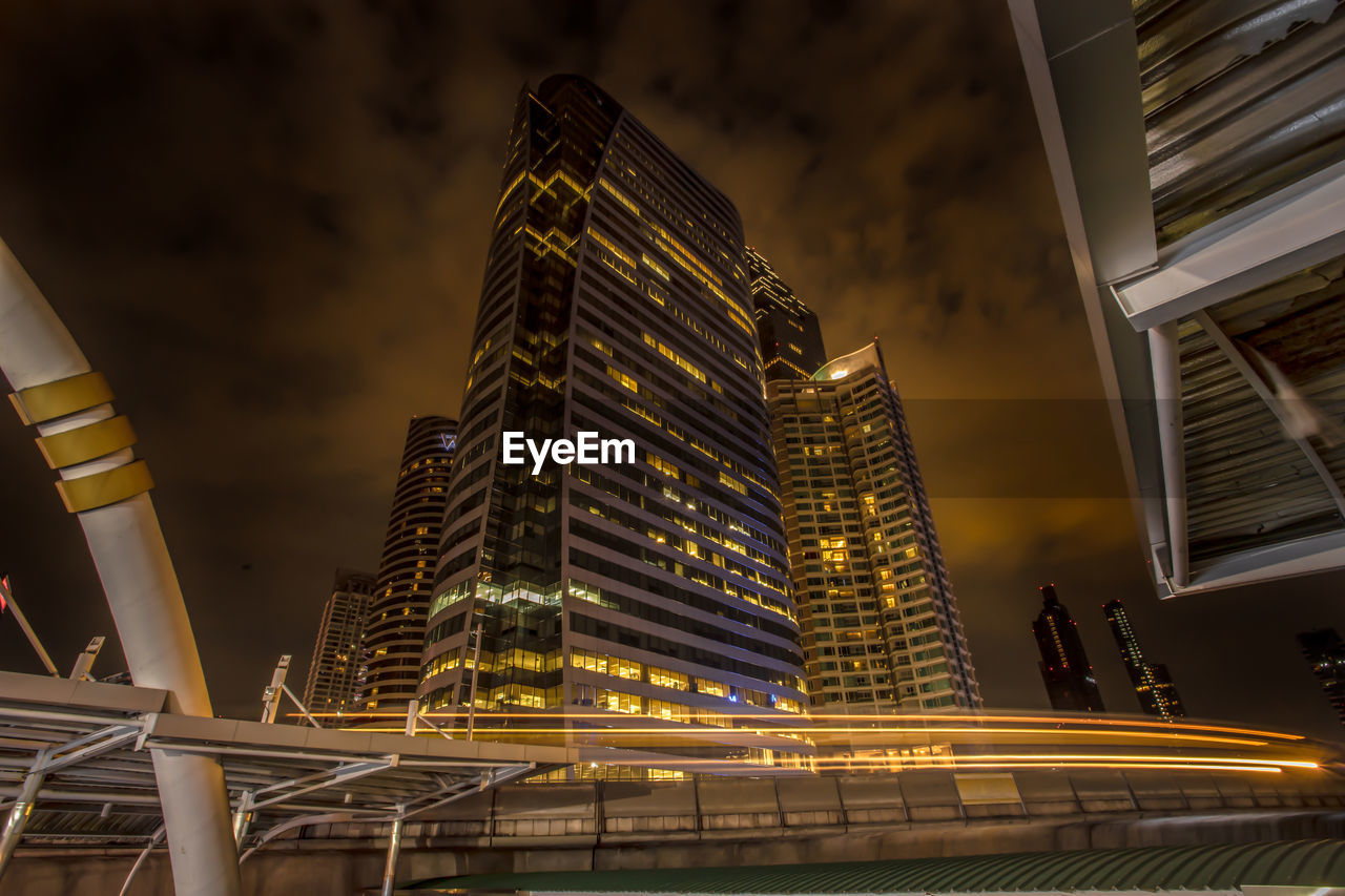 LOW ANGLE VIEW OF ILLUMINATED MODERN BUILDINGS IN CITY AT NIGHT