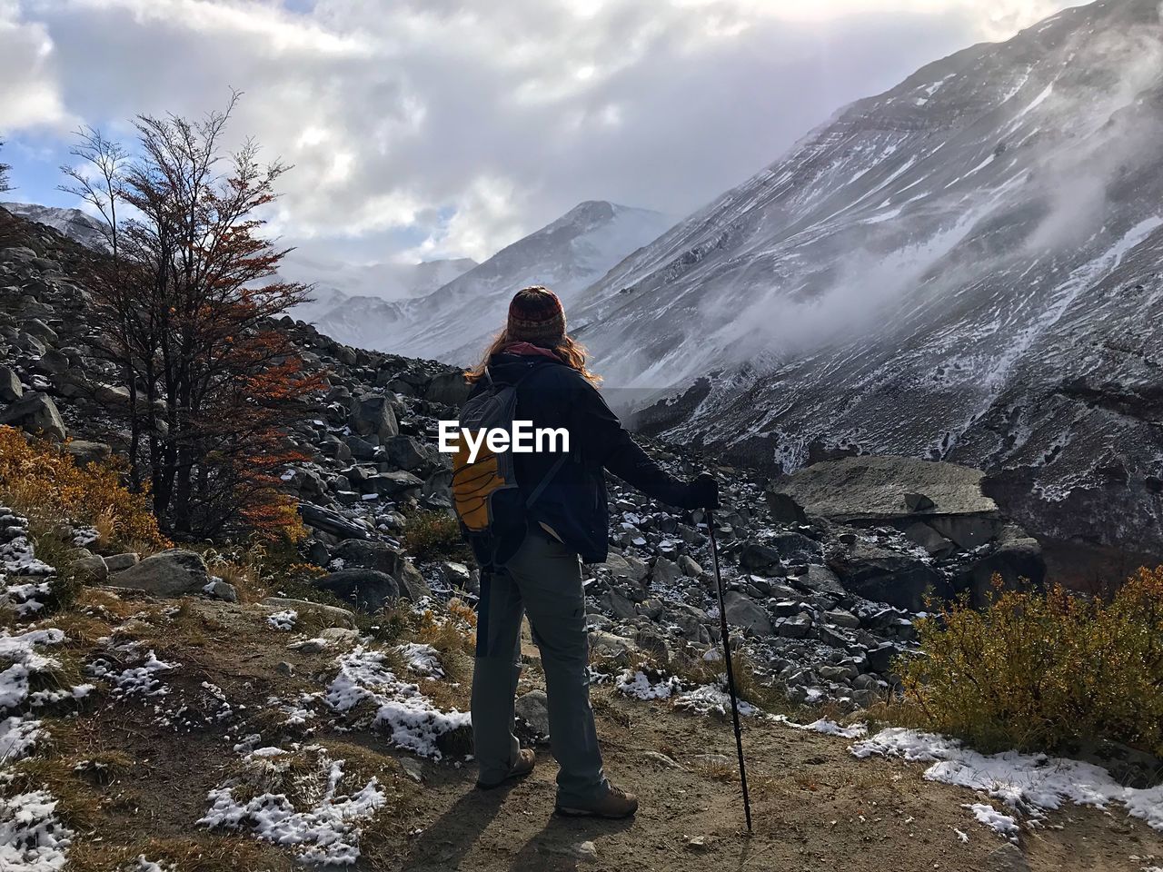 Hiker standing against snowcapped mountains