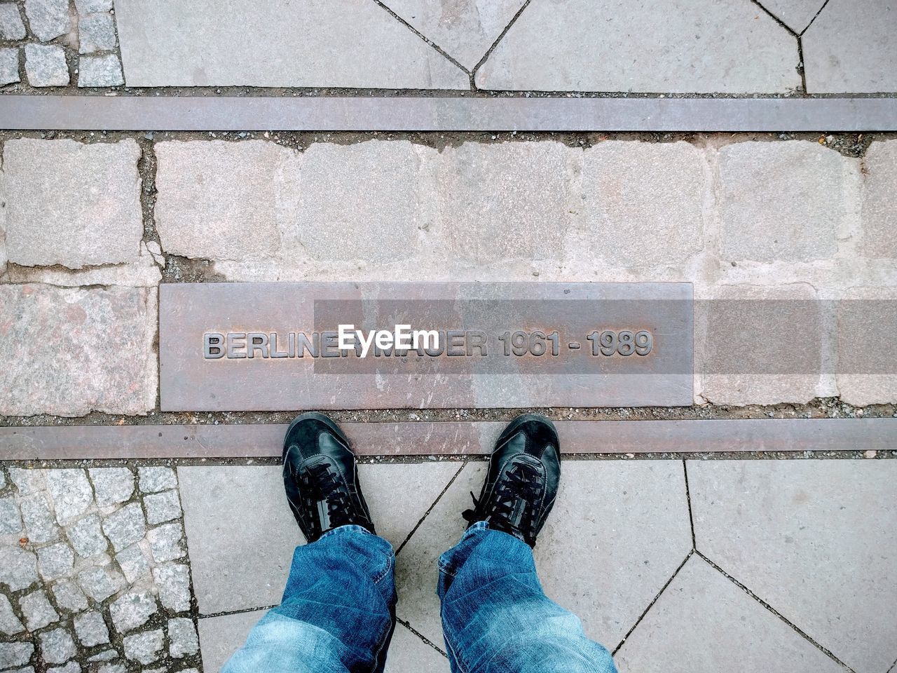 Low section of man standing on pavement