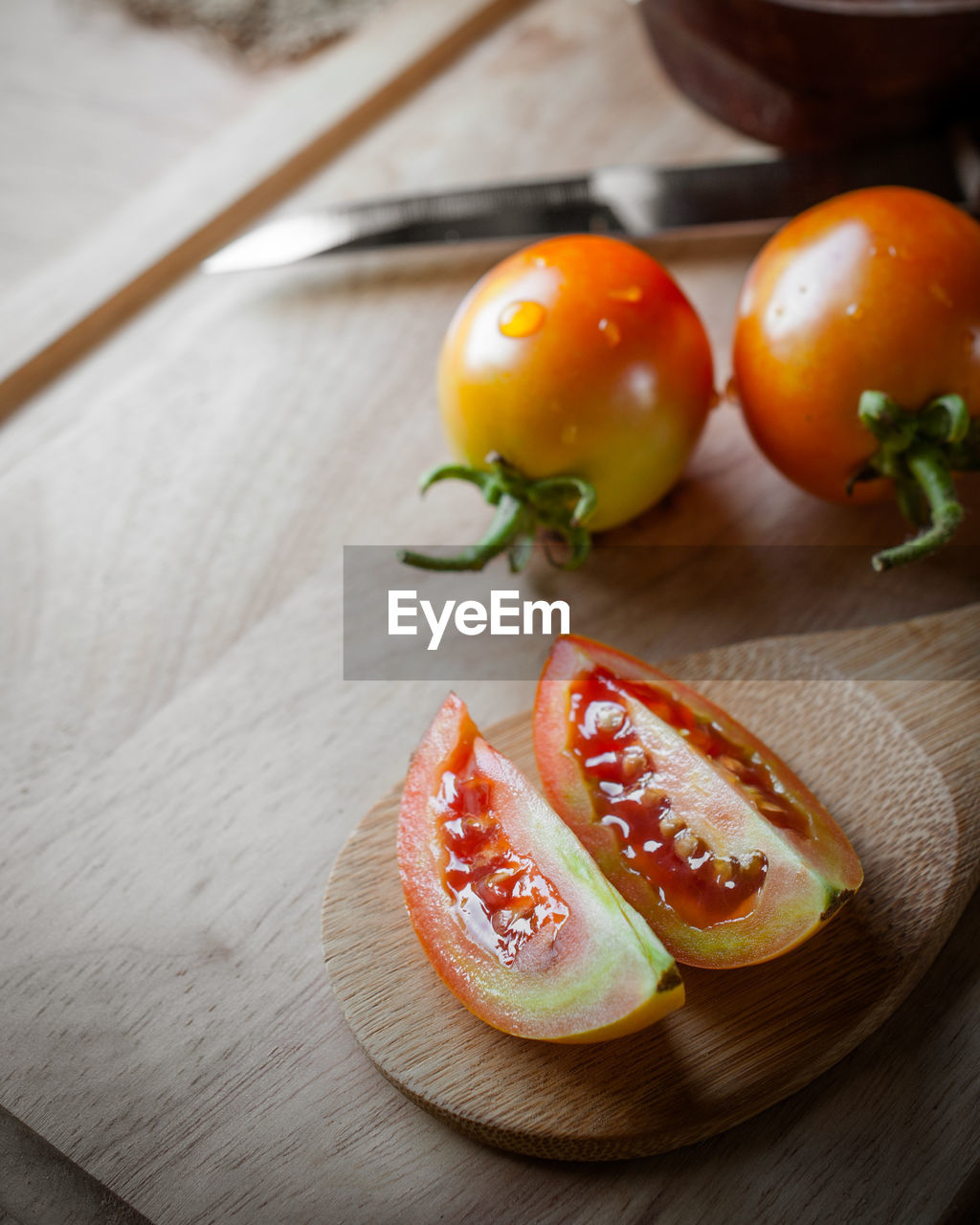 High angle view of tomatoes on cutting board at table