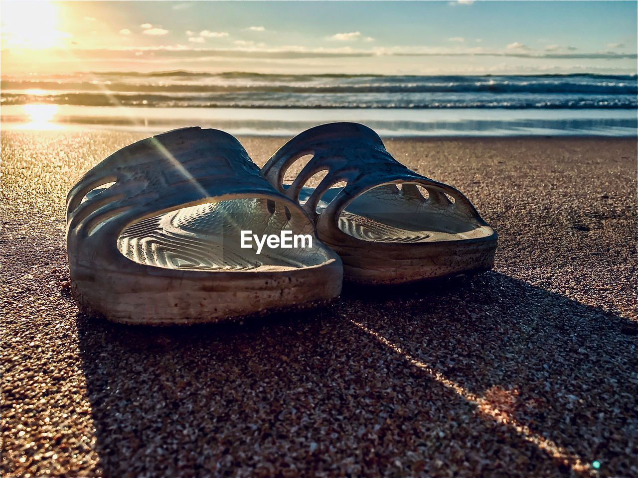 Close-up of shoes on beach