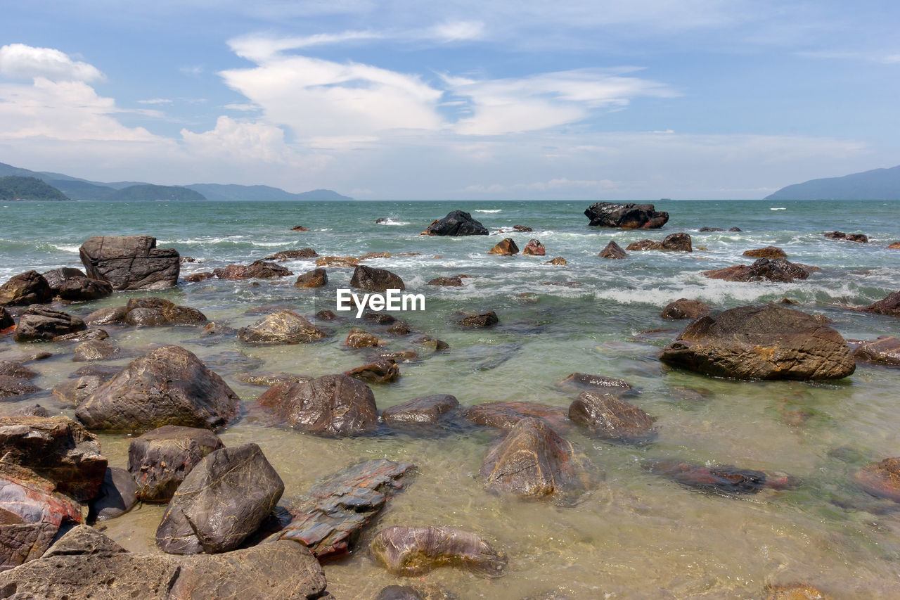 ROCKS ON SHORE AGAINST SKY