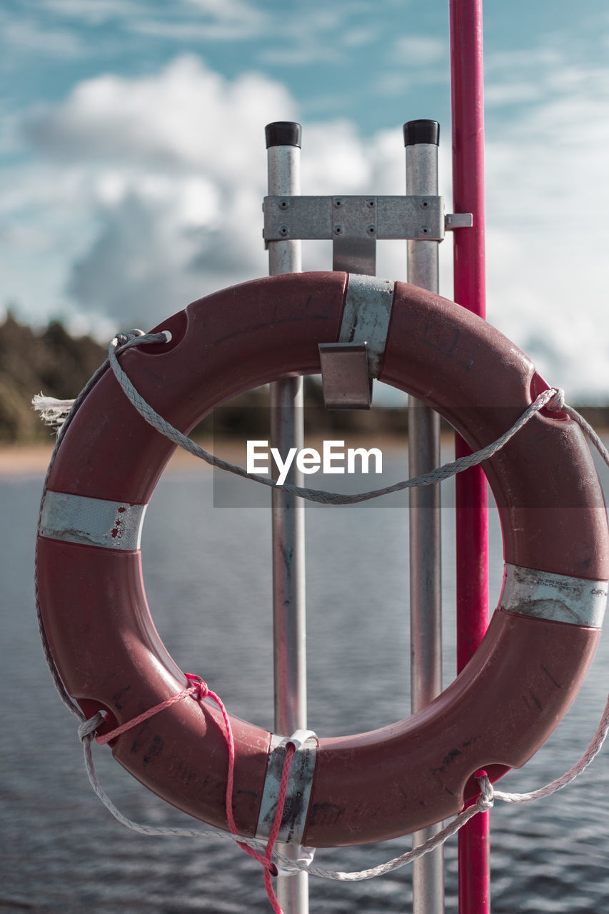 Close-up of lifebelt in sea against sky