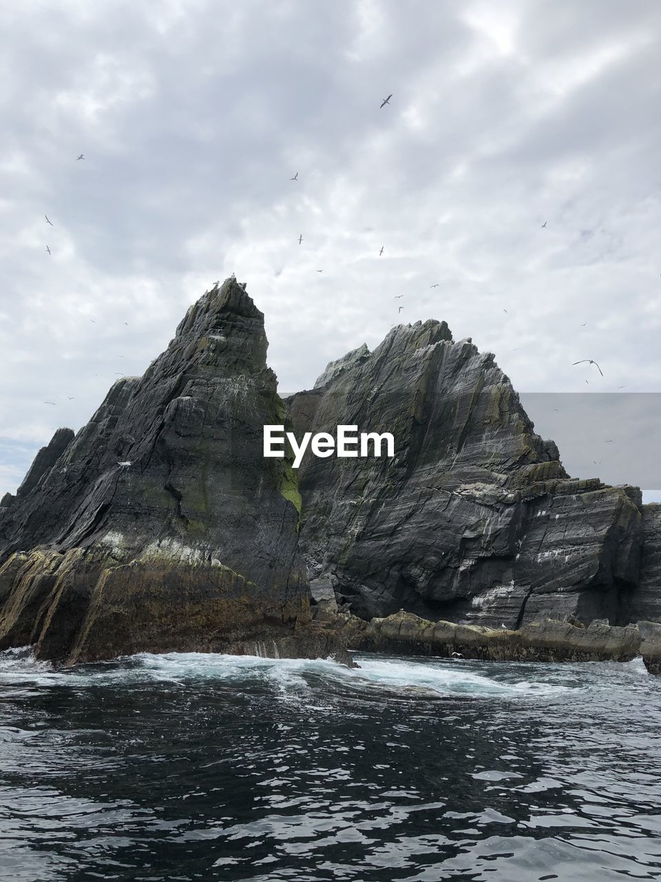 Rock formation in sea against sky