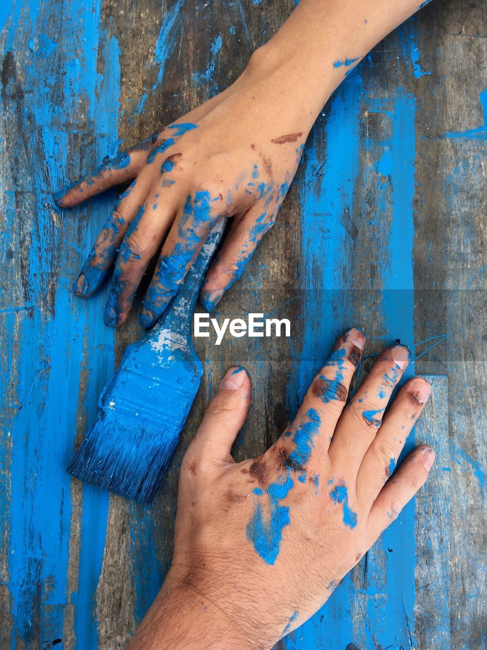 Close-up of hands on blue wood