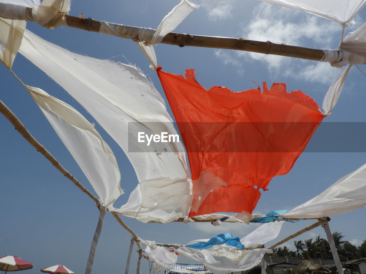 Low angle view of flags hanging on pole against sky