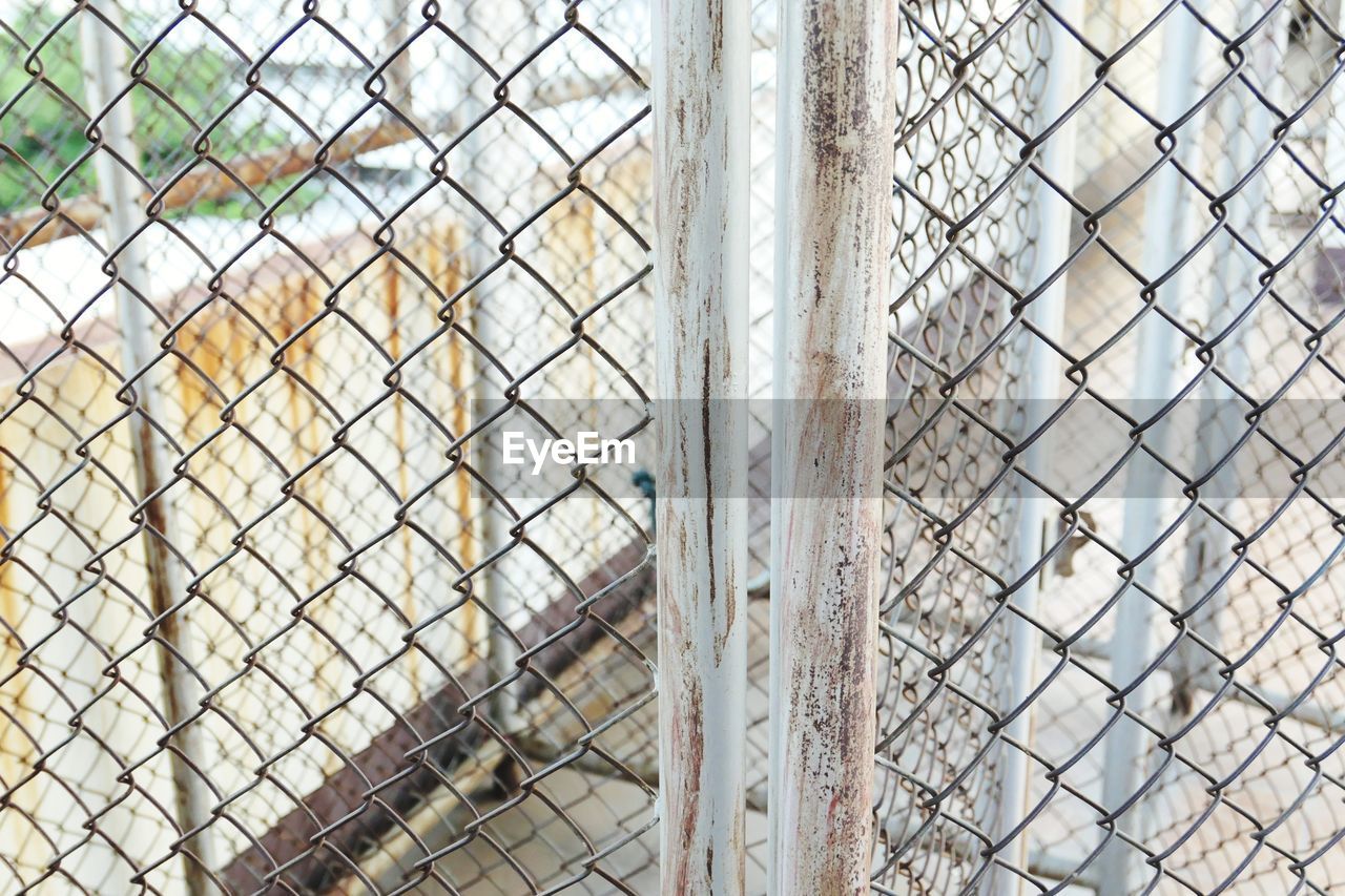 FULL FRAME SHOT OF CHAINLINK FENCE IN CAGE SEEN THROUGH METAL