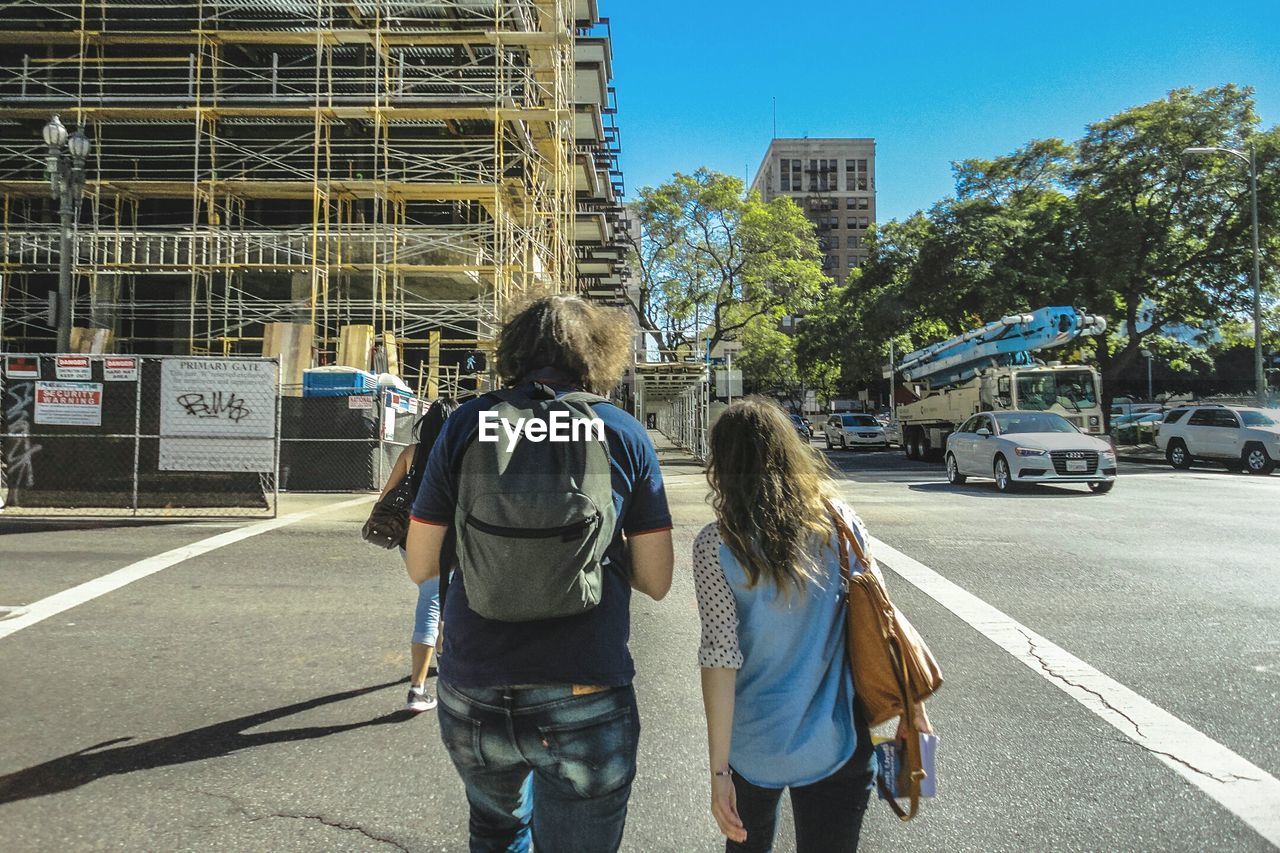 Three people walking on road