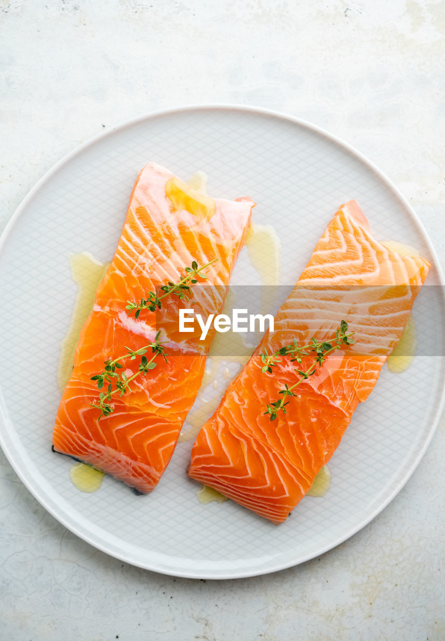 Fresh salmon fillet with herbs on a plate for delicious salmon steak.