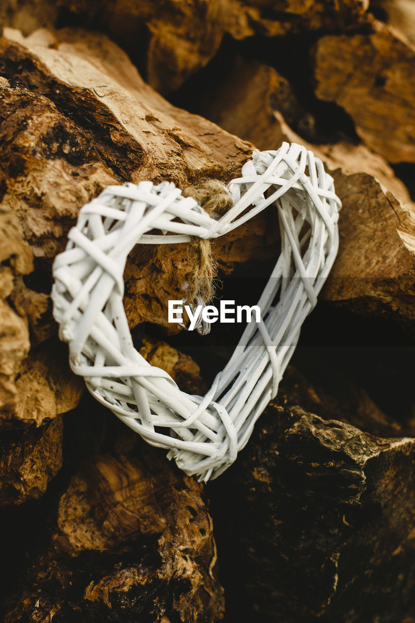 Close-up of heart shape decoration with rings on rock