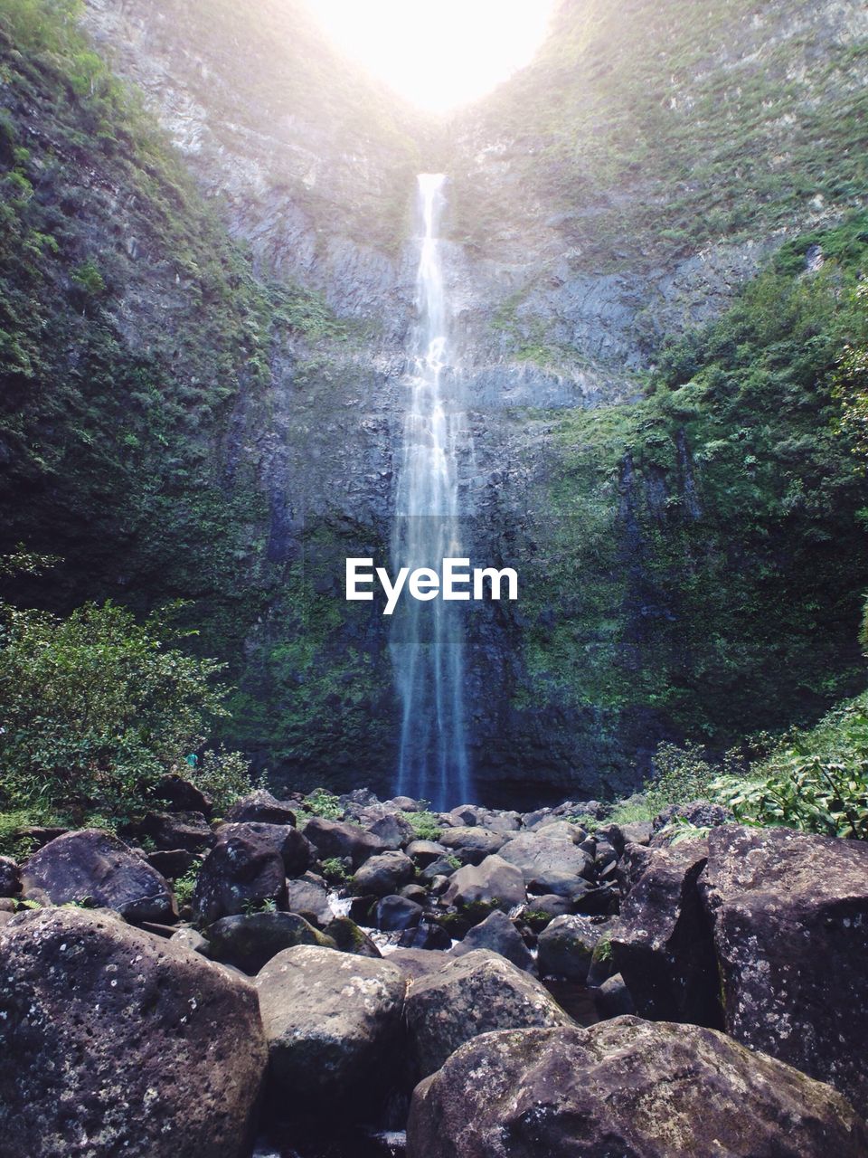 Low angle view of waterfall on sunny day