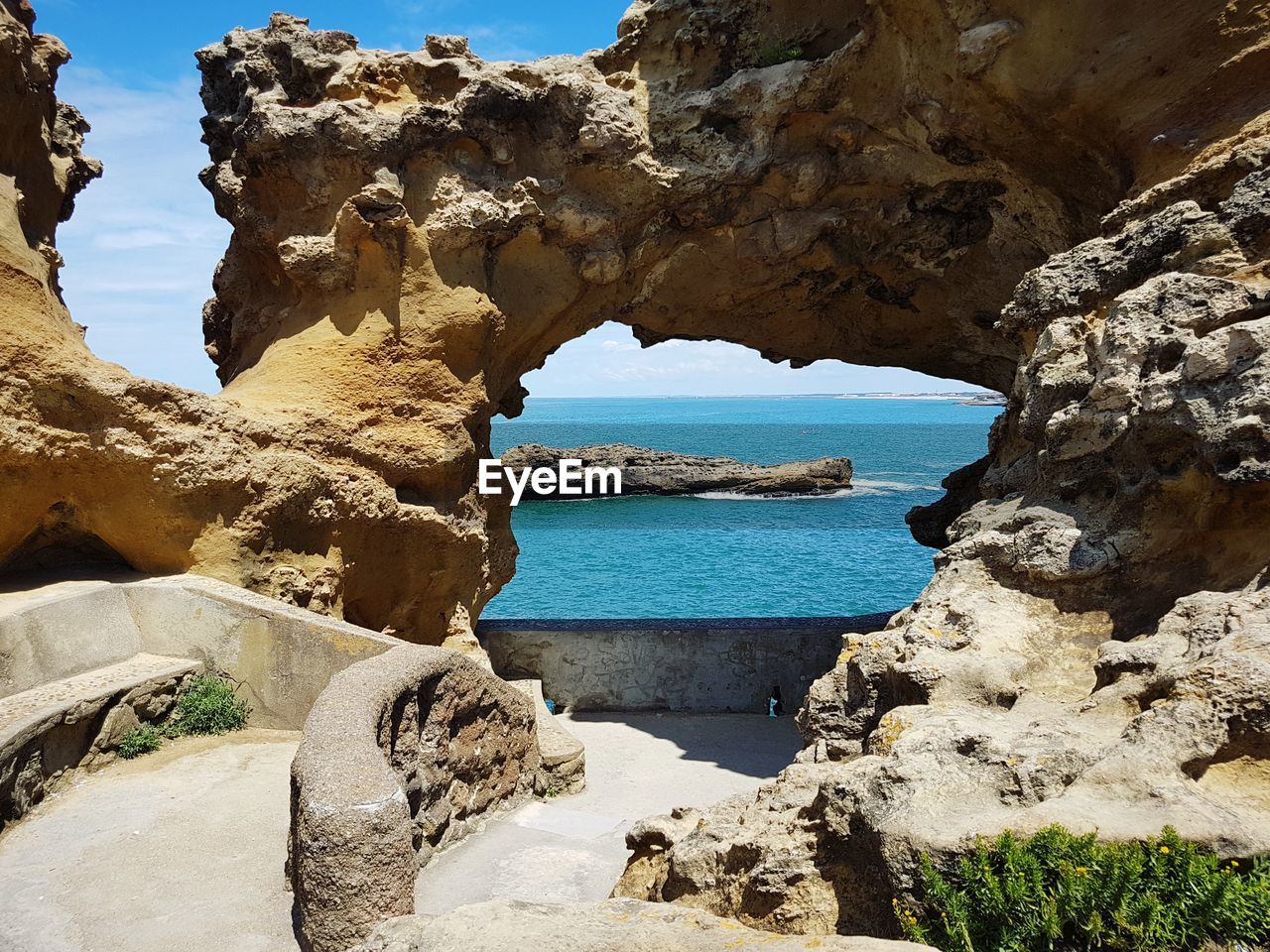 Scenic view of rock formation in sea against sky