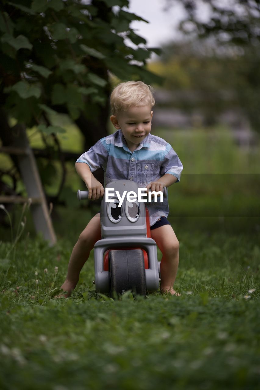 Portrait of boy playing with toy on field